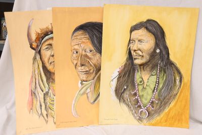 trois peintures d'hommes indiens sont exposées sur une table