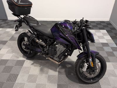 une moto violette et noire garée sur un sol à damier dans un garage