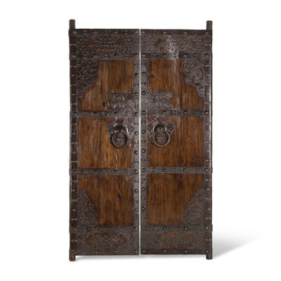 une photo représentant une paire de portes en bois dotées de ferrures métalliques