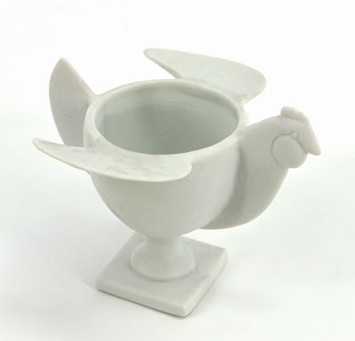 a white vase with a bird on it on a stand