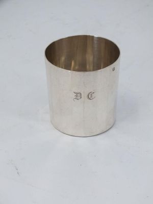 a close up of a silver cup on a white surface