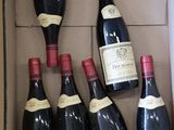 bouteilles de vin rouge dans un carton sur une table
