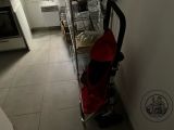 a baby stroller that is in a kitchen next to a stove