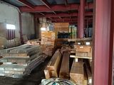 a large pile of wood in a warehouse with lots of pallets