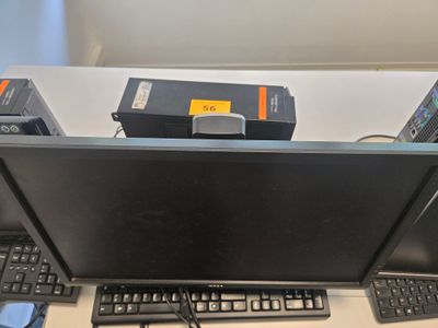 une photo d'un bureau d'ordinateur avec un écran, un clavier et une souris