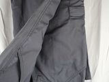 a pair of grey cargo pants laying on top of a white sheet