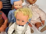 five dolls sitting next to each other on a white surface
