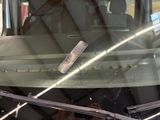 a broken windshield with a remote control attached to it
