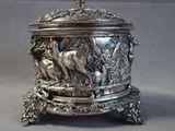 a silver box with a bird on it sitting on a table