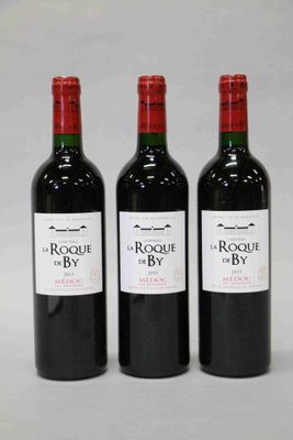 trois bouteilles de vin rouge posées côte à côte sur une table