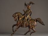 statue of a man riding a horse with a spear on its back