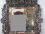 un miroir ouvragé avec un cadre argenté sur fond blanc