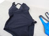 two swimsuits are laying on the floor next to each other