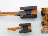 a yellow toy tractor and a black toy tractor on a white surface