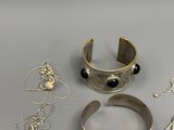 silver bracelets, bracelets, and other jewelry on a table