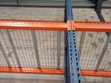 an overhead view of a rack in a warehouse with a metal fence