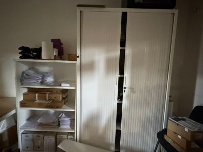 un placard situé dans un coin d'une pièce où il y a beaucoup de cartons par terre
