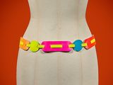 multicolored plastic belt on mannequin torso with orange background
