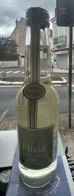 a bottle of wine sitting on a table outside