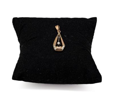un oreiller noir orné d'un pendentif doré