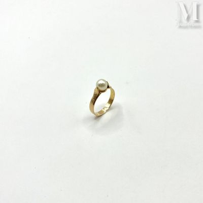 a close up of a gold ring with a pearl on it