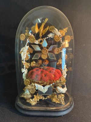 une cloche en verre contenant un objet rouge