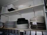many plates and pans on the shelves in the kitchen