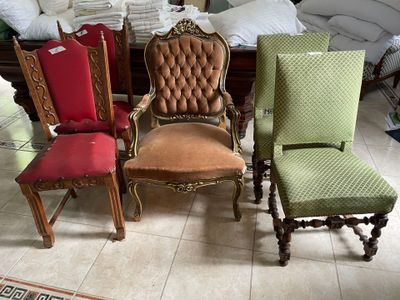 several chairs are lined up in a room with a bed in the background
