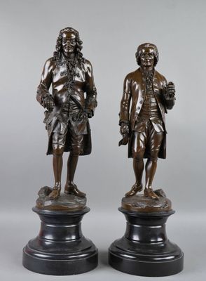 two bronze statues of a man and a woman standing next to each other