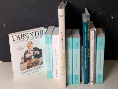 Plusieurs livres sont empilés les uns sur les autres devant un mur noir.