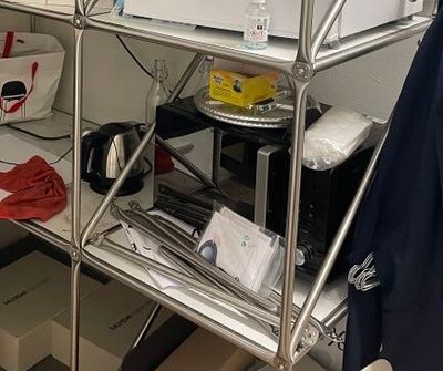 un micro-ondes posé sur une étagère métallique dans une pièce
