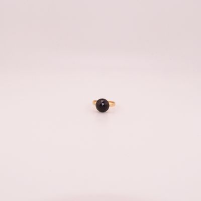 un seul anneau de pierre noire sur une surface blanche