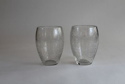 two glasses sitting next to each other on a white surface