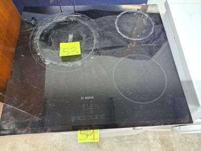 une plaque de cuisson en verre avec un brûleur noir et un autocollant jaune dessus