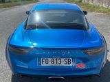 une voiture de sport bleue garée sur le bord de la route