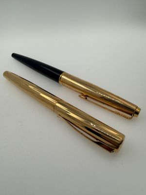 two pens sitting on top of each other on a table
