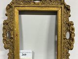 un miroir à cadre doré posé sur une table en bois
