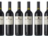 six bottles of red wine are lined up in a row
