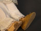 a close up of a doll ' s legs and shoes