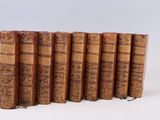 plusieurs vieux livres sont alignés sur une surface blanche
