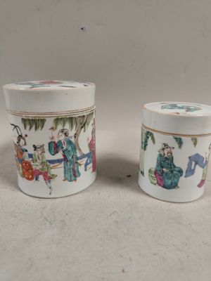pair of chinese porcelain cups with figures on them on a table
