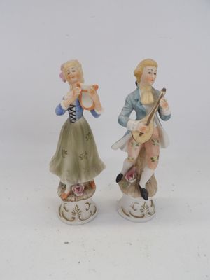 deux figurines représentant un homme et une femme en train de jouer de la musique