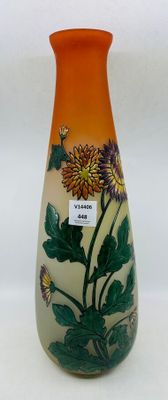 un vase avec des fleurs peintes dessus, posé sur une table