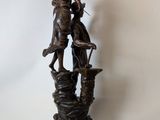 statue of a man and a woman on a rock with a dog