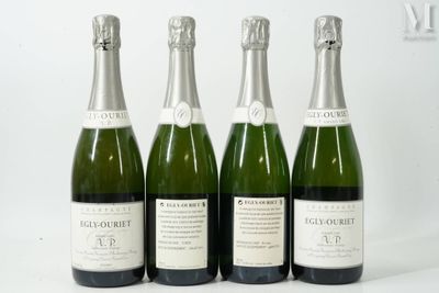 quatre bouteilles de champagne sont alignées sur une surface blanche