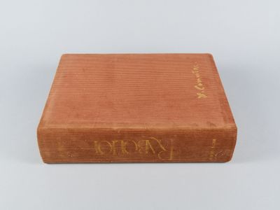 un livre brun posé sur une surface blanche