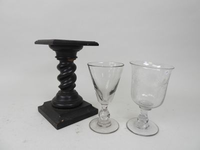 two wine glasses and a candle holder on the table