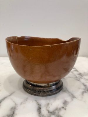brown ceramic bowl sitting on top of a marble counter top