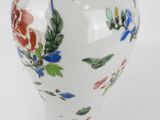 a white vase with a floral design on it