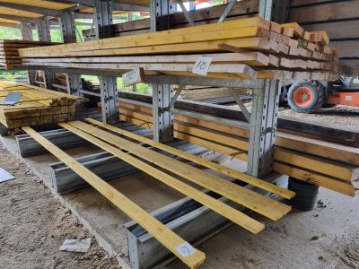de nombreuses pièces de bois empilées sur une palette dans un entrepôt